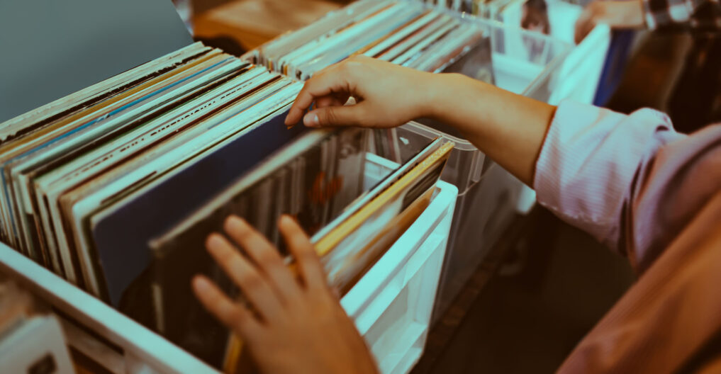 Woman is choosing a vinyl record in a musical store Woman is choosing a vinyl record in a musical store