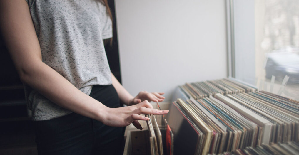 Choosing retro vinyl records. Music background Choosing retro vinyl records. Music background. Unrecognizable woman in musical shop, old school hipster style