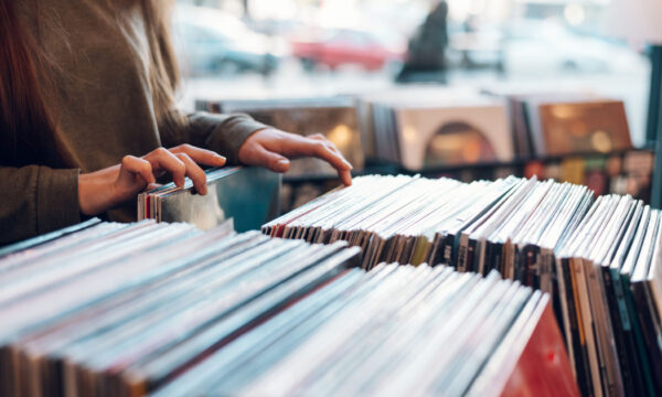 Woman hands choosing vinyl record in music record shop Close up of a woman hands choosing vinyl record in music record shop. Music addict concept. Old school classic concept. Focus on the hands and a vinyl record.
